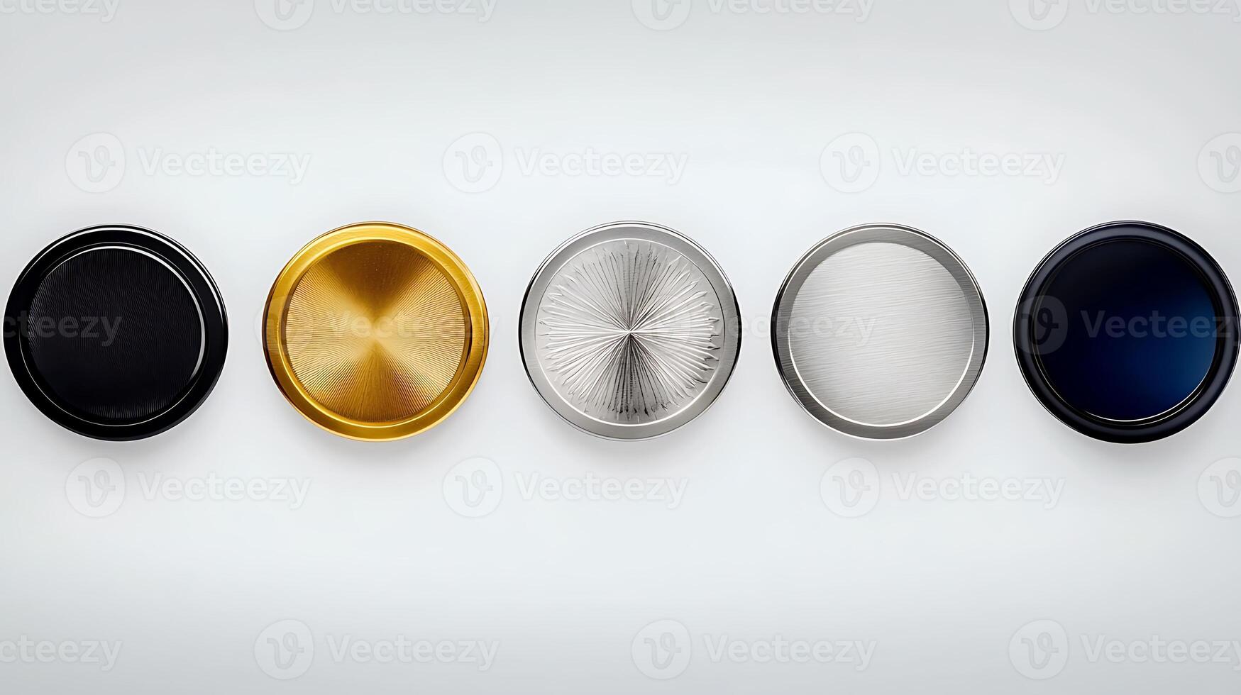 Close-up view of five circular metallic caps in varying finishes arranged on a smooth surface photo