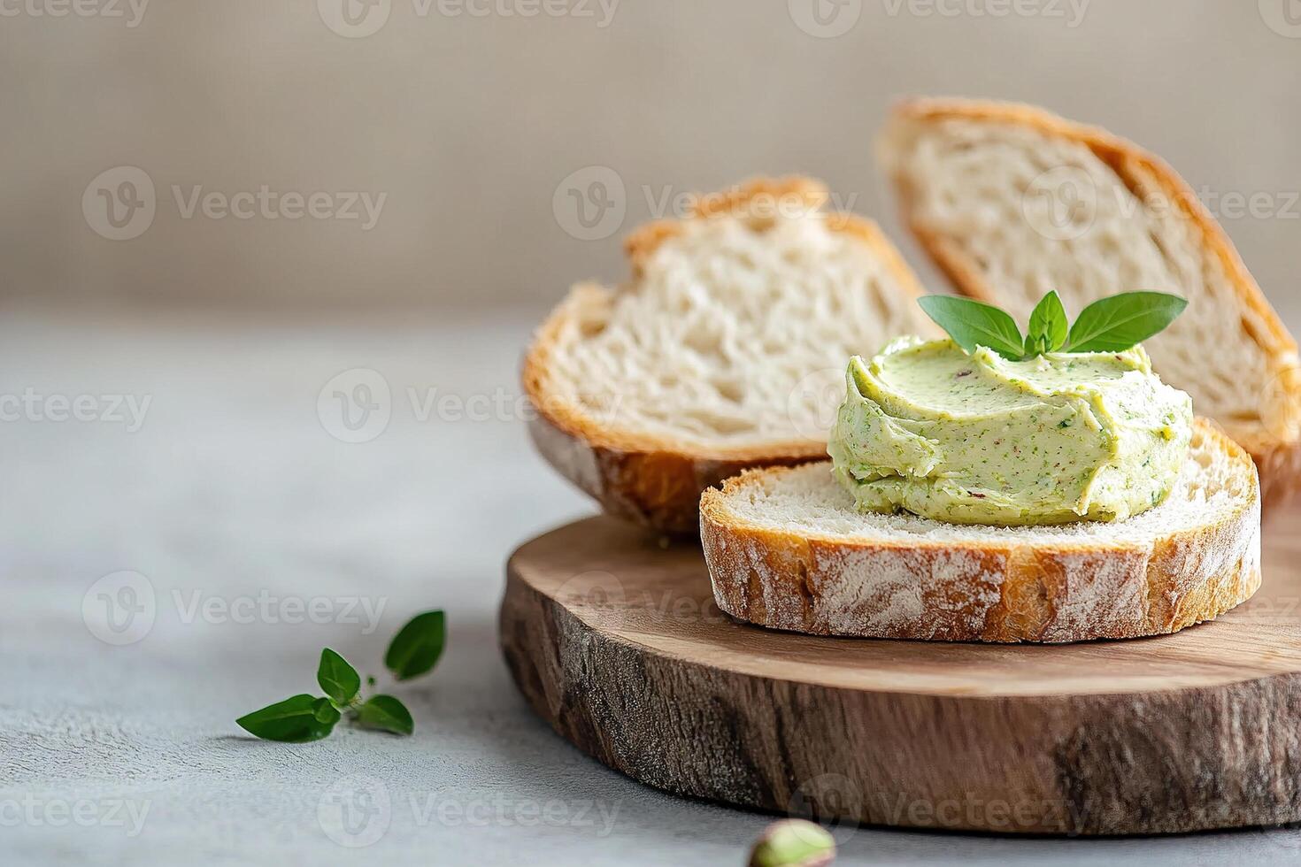 A golden slice of warm, crusty bread is spread generously with smooth pistachio butter, resting on a rustic wooden board. Softly blurred textures create a cozy atmosphere photo