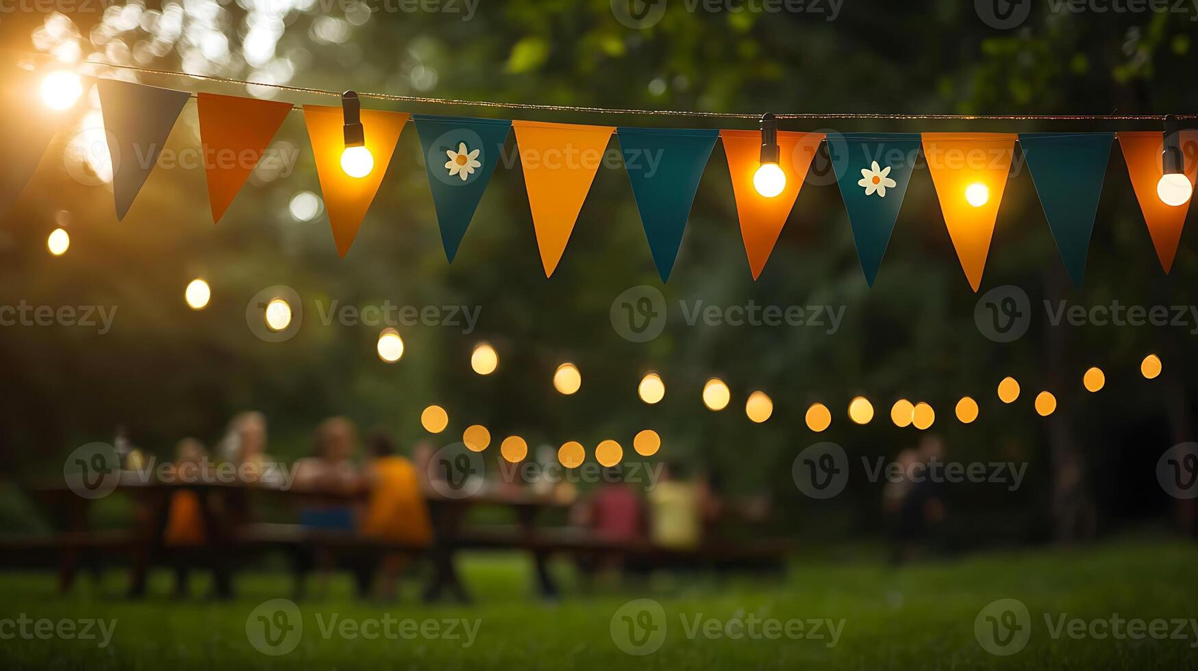 Colorful bunting and glowing lights adorn a festive outdoor gathering in a lush green park photo