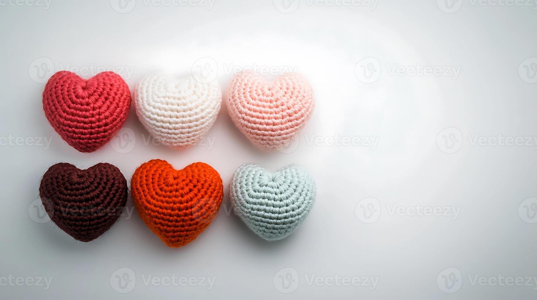 Colorful crocheted hearts arranged in a row on a soft background, symbolizing love and creativity photo