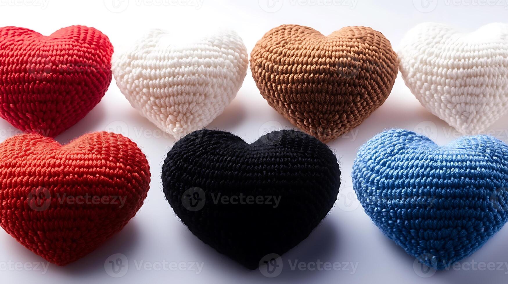 Colorful crocheted heart-shaped cushions arranged in a creative display on a white background photo