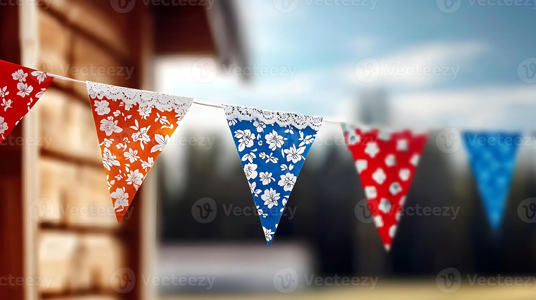 Colorful decorative bunting flags hanging against a rustic wooden cabin in a serene outdoor setting photo