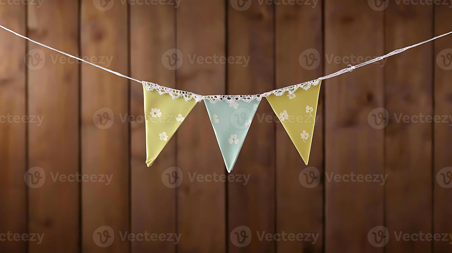 Colorful decorative bunting with floral patterns hanging against a rustic wooden backdrop photo