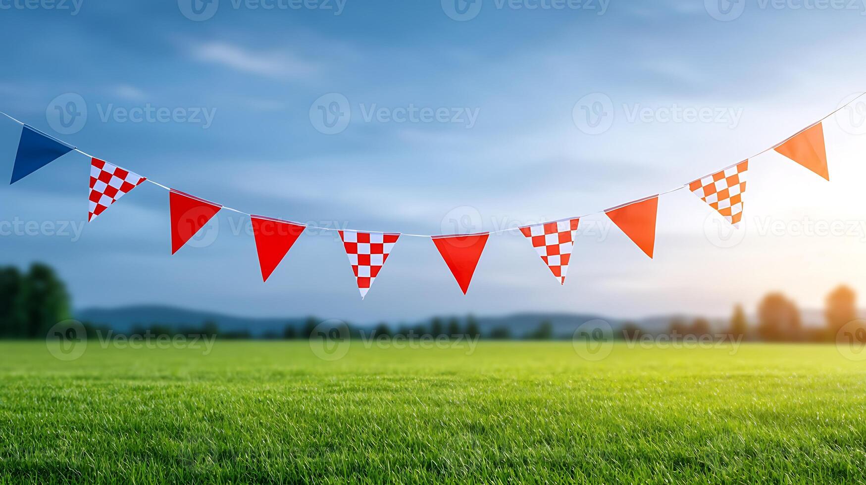 Colorful flags strung across a vibrant green field under a blue sky at sunset photo