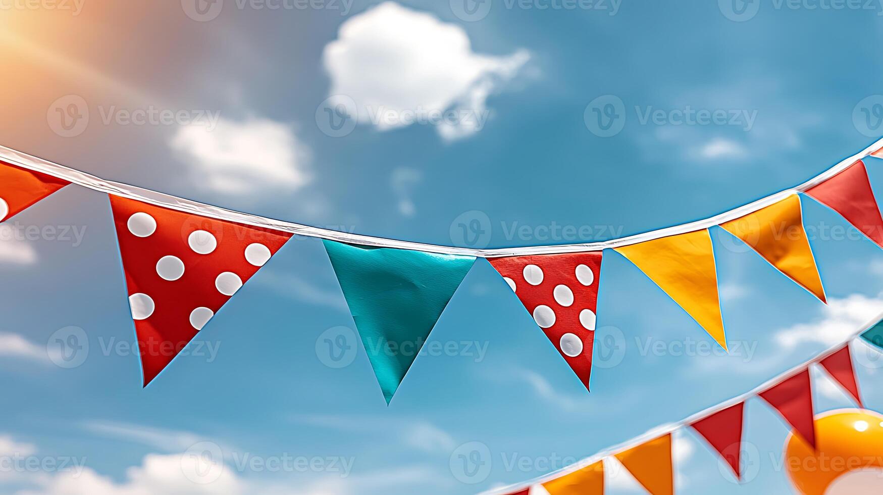 Colorful party bunting flags fluttering against a bright blue sky with fluffy clouds photo