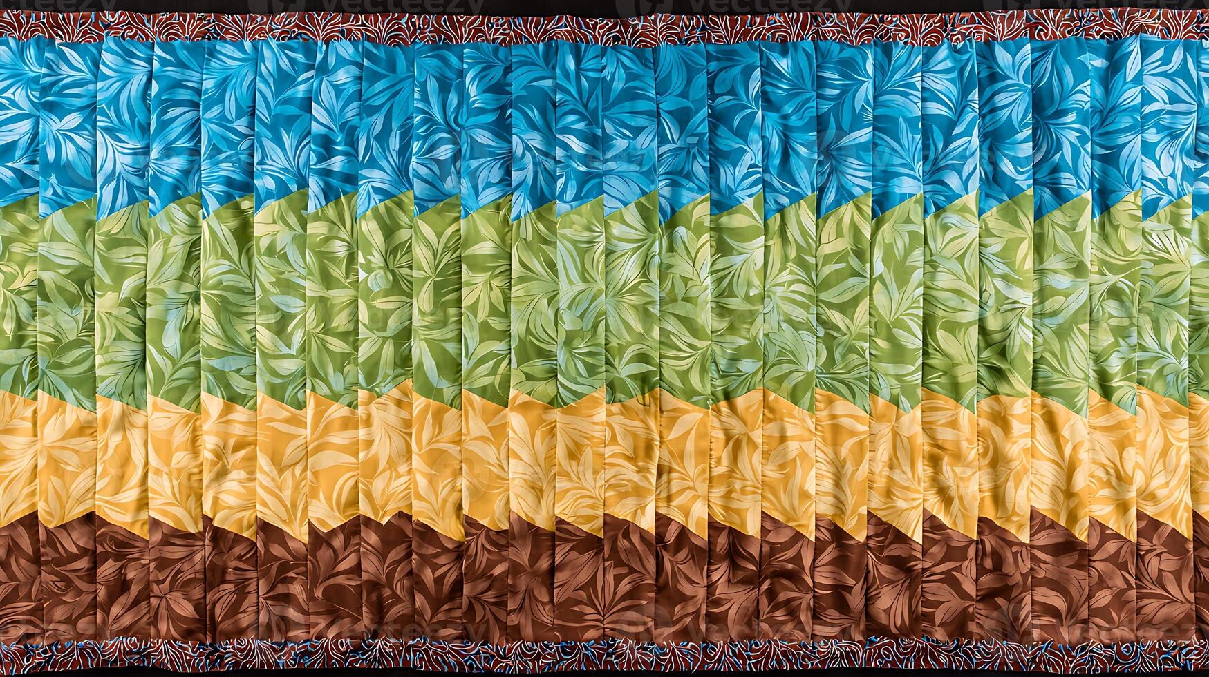 Colorful quilt featuring layered leaf patterns in blue, green, yellow, and brown hues photo