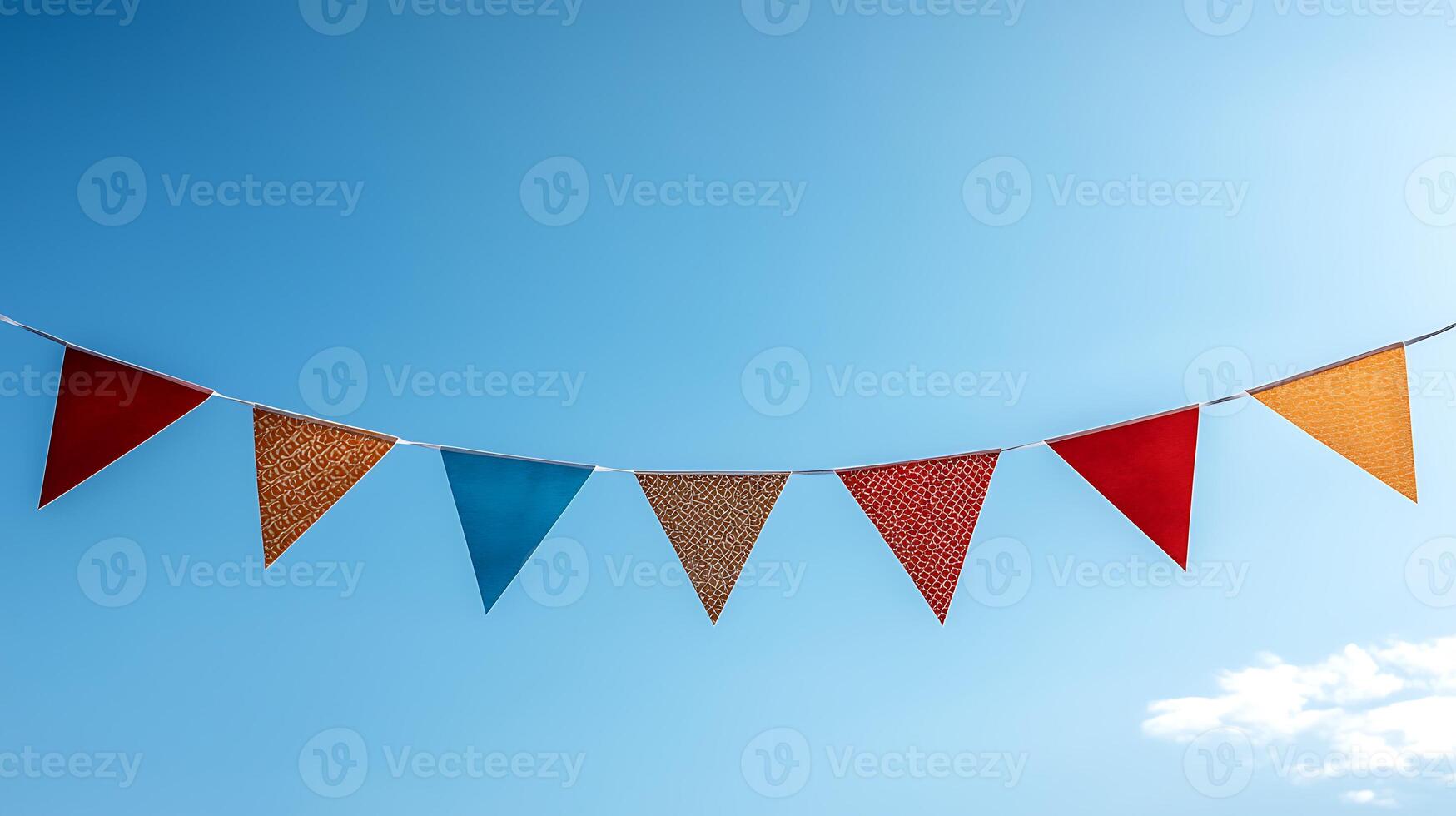 Colorful triangular flags strung against a clear blue sky, creating a festive atmosphere outdoors photo
