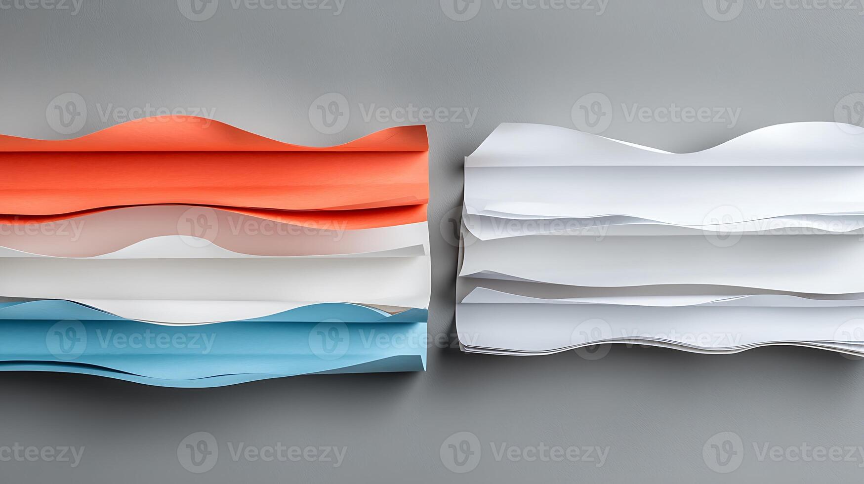 Colorful waves of paper in orange, white, and blue arranged artistically on a gray background photo