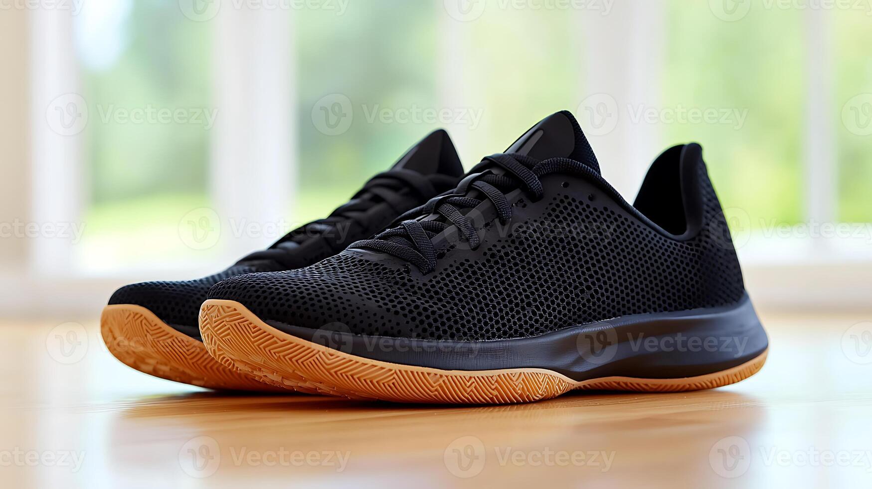 Stylish black athletic shoes on a wooden floor with natural light streaming through windows photo