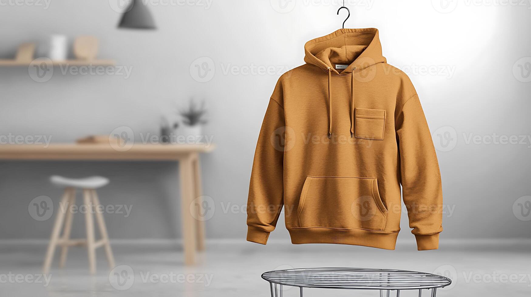 Stylish mustard hoodie displayed on a hanger in a modern, minimalistic living room setting photo