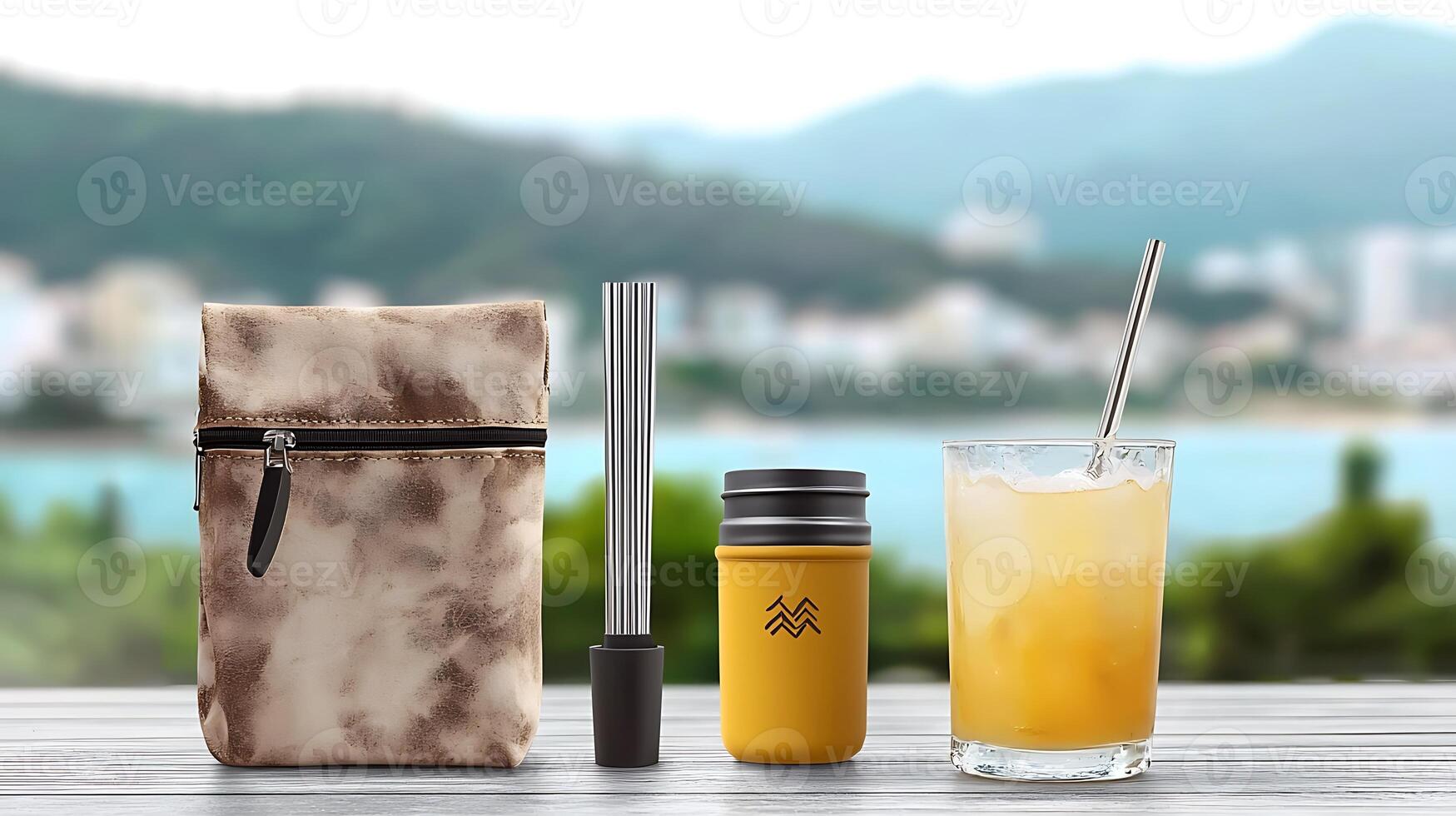 Stylish outdoor setting featuring a reusable drink container, straw, and a refreshing beverage by the beach photo