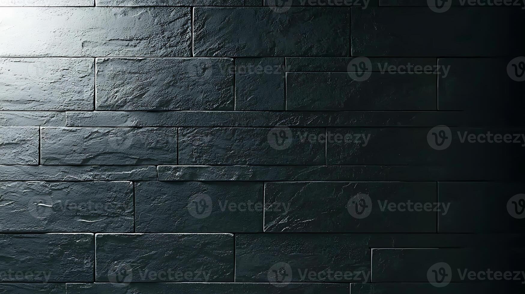 Textured dark stone wall illuminated from the left, creating shadows and depth effects photo