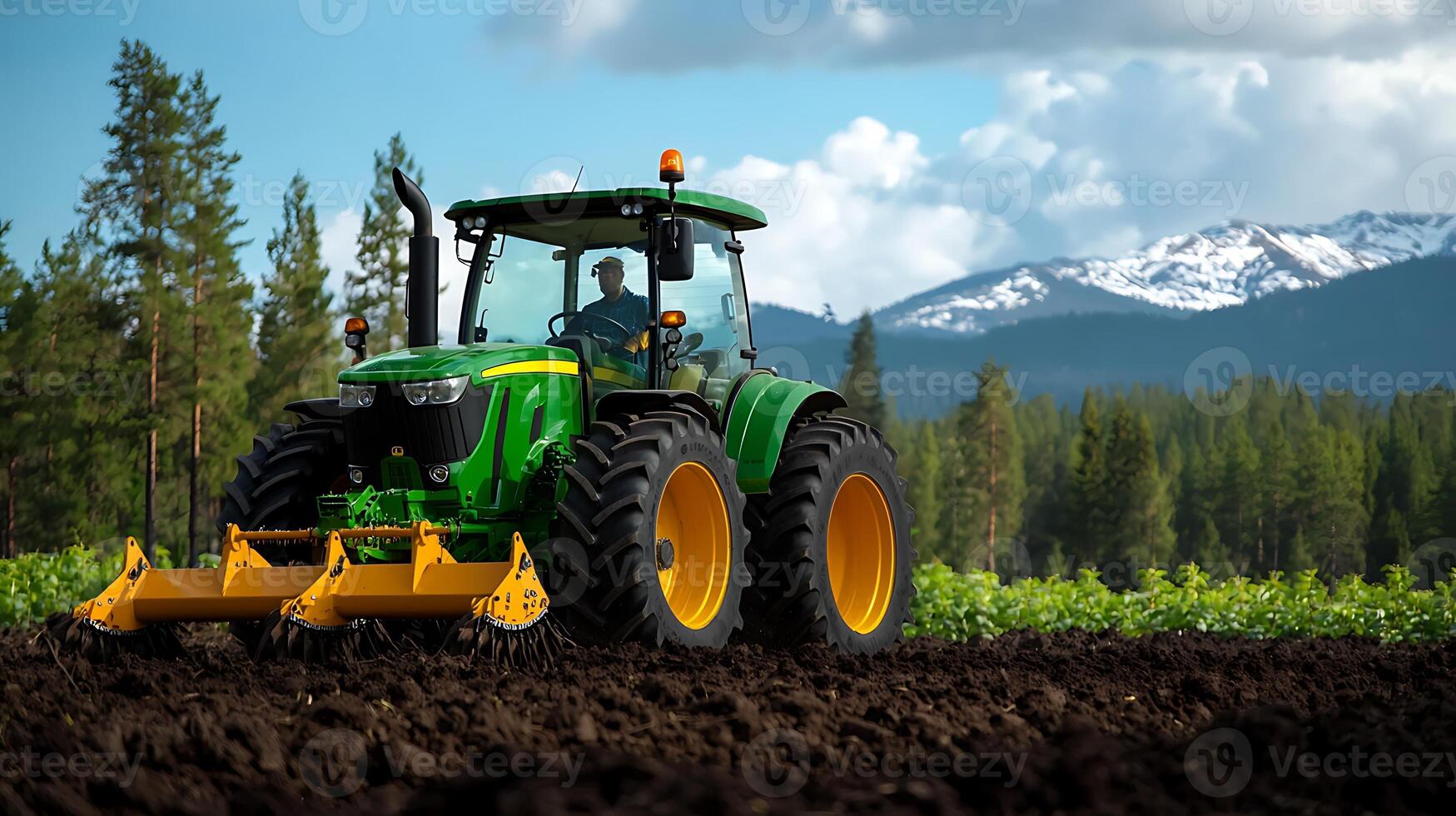 Tractor plowing a field with mountains in the background under a blue sky photo