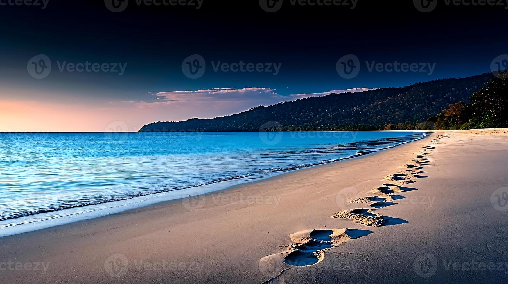 Tranquil beach scene at sunset with footprints leading to the calm ocean and distant hills photo