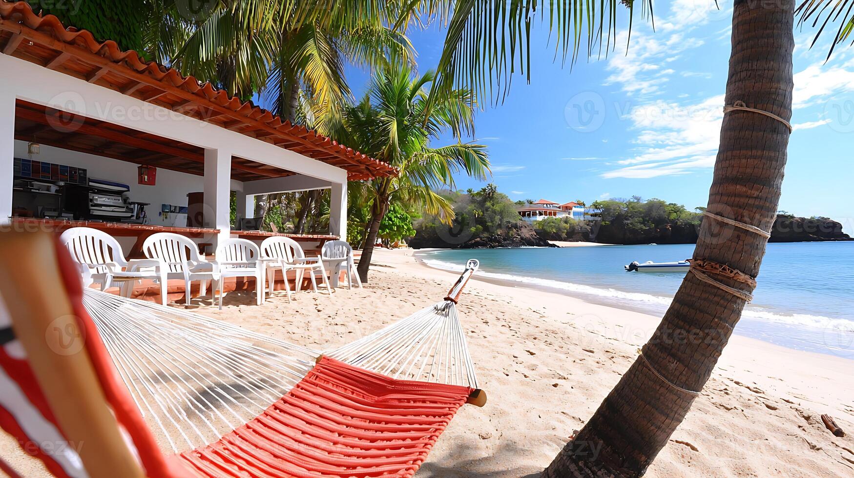Tranquil beach scene featuring a hammock, palm trees, and a serene ocean view with distant houses photo