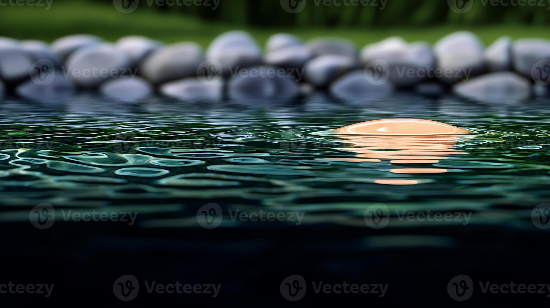 Tranquil pond reflecting a soft sunset, surrounded by smooth stones and lush greenery photo