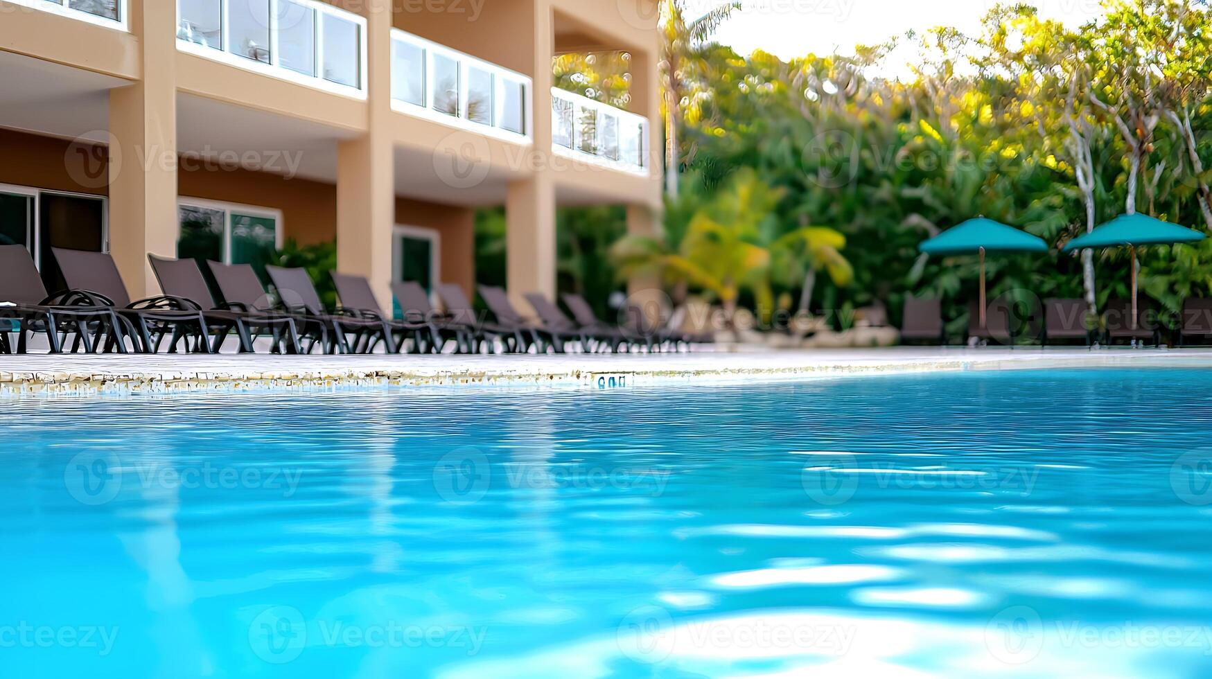 Tranquil resort poolside with lounge chairs, surrounded by tropical greenery and sunny ambiance photo