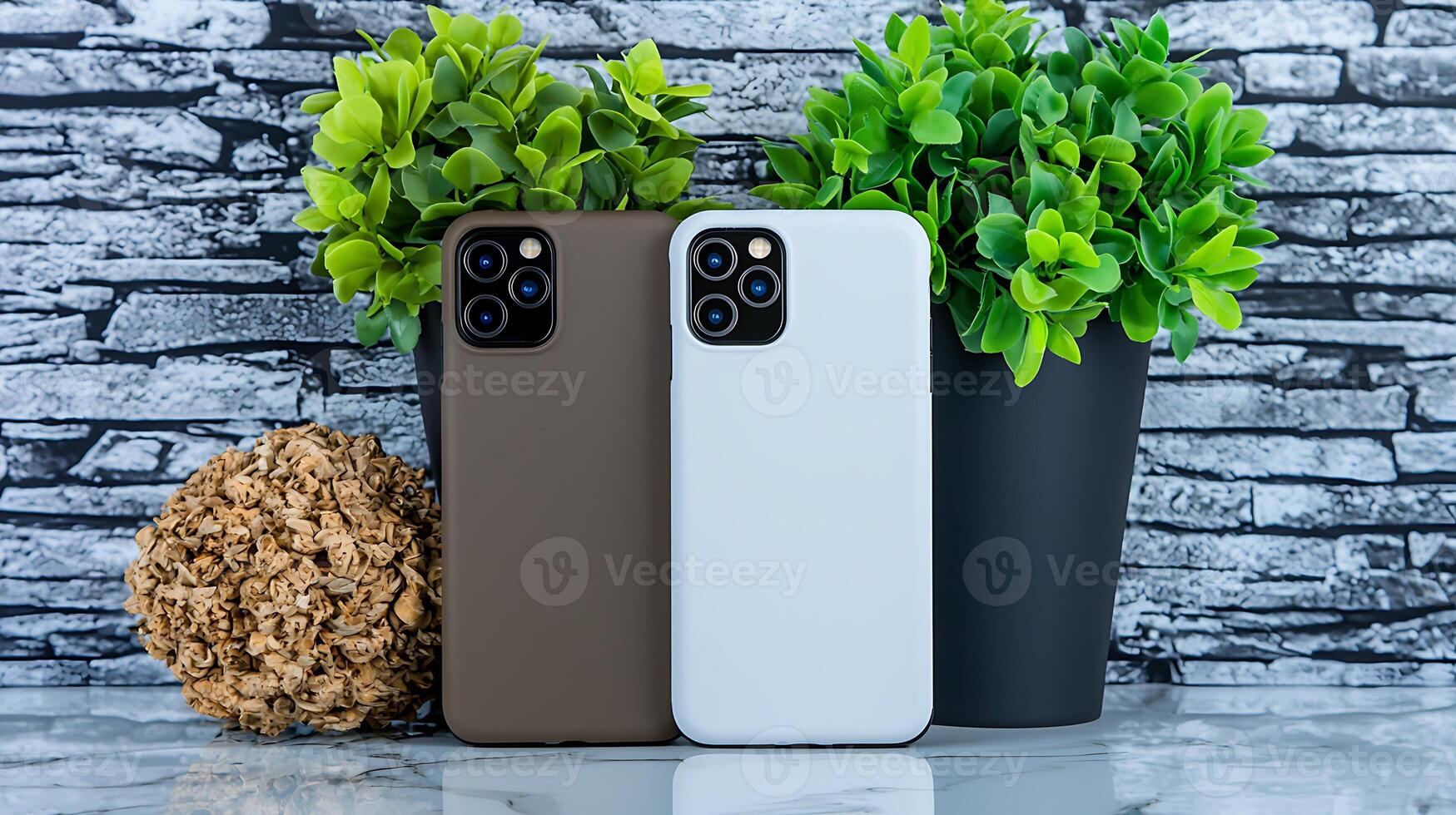 Two mobile phones with protective cases displayed next to decorative plants on a stone background photo