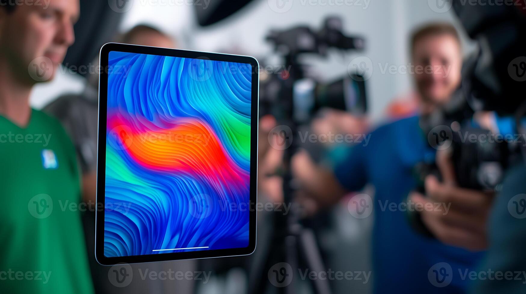 Two photographers capture an image of a vibrant tablet screen in a studio setting photo