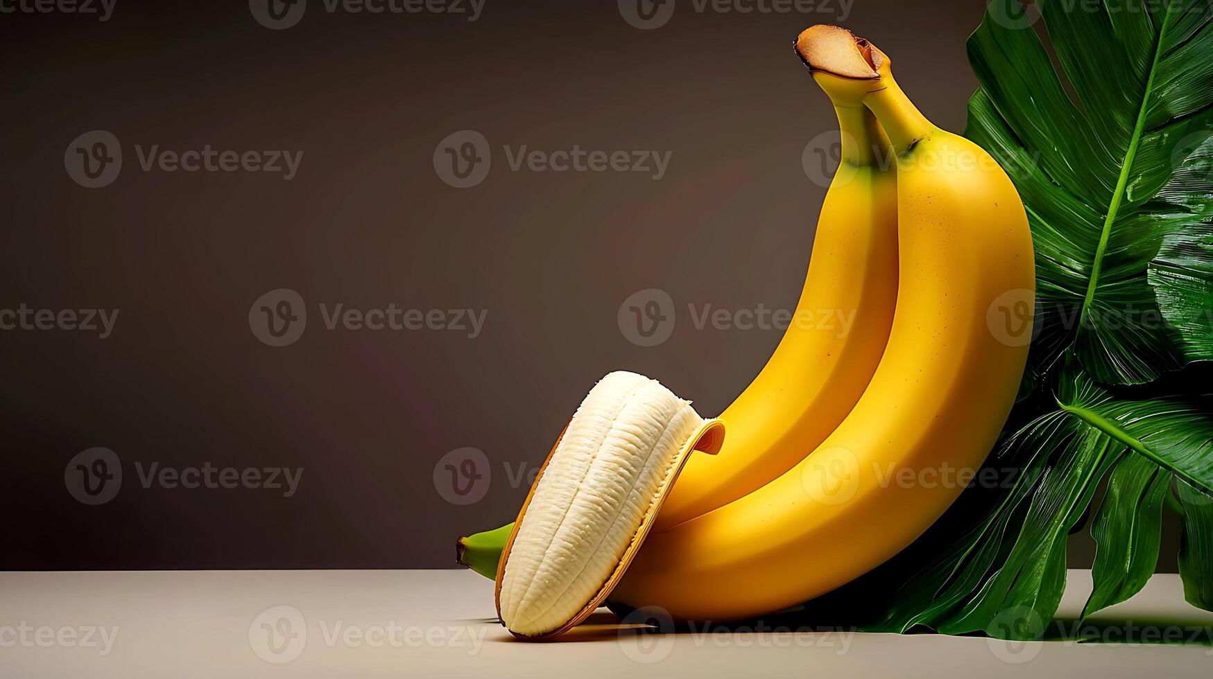 Two ripe bananas beside a large green leaf on a neutral background, showcasing freshness and vitality photo