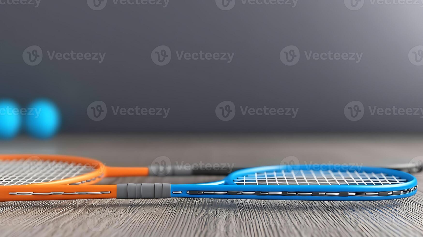 Two tennis rackets positioned on a wooden surface with blue balls in the background photo