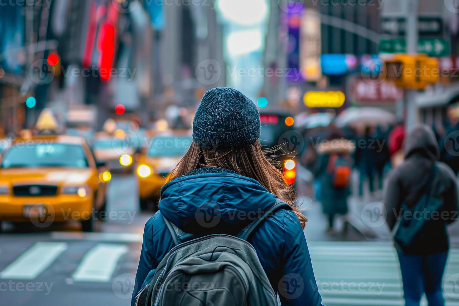 A woman with a backpack walking down a busy street photo