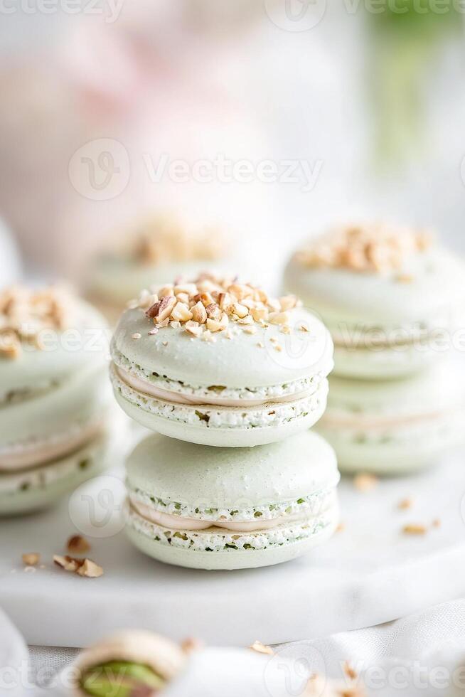 Pastel-green pistachio macarons are artfully stacked on a marble tray, their surfaces dusted with crushed nuts. Gentle natural light enhances their delicate appearance photo