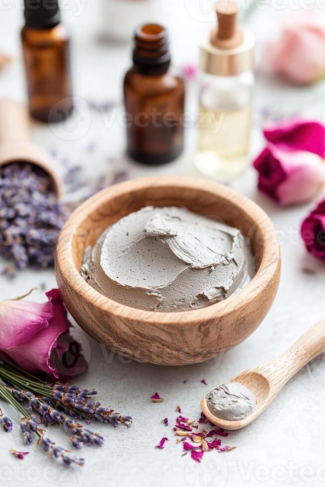 A serene spa arrangement features a clay mask in a wooden bowl, surrounded by dried lavender, rose petals, and essential oil bottles, creating a tranquil atmosphere for self-care photo