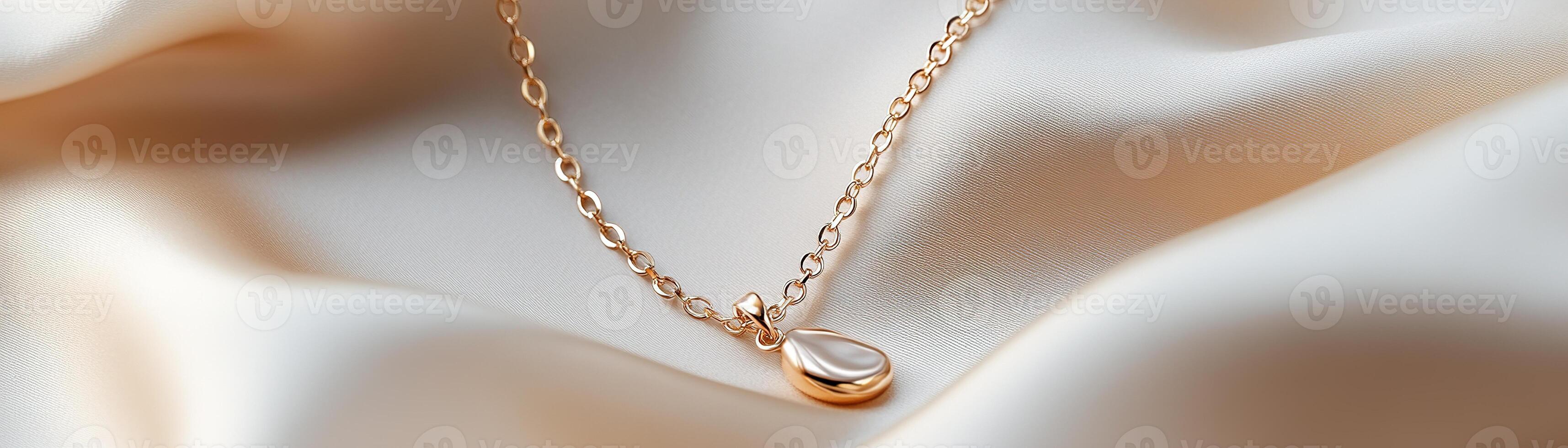 A delicate gold-plated necklace with a refined one-line art design rests gracefully on soft silk fabric. The high-contrast lighting enhances the elegance and luxury of the piece photo