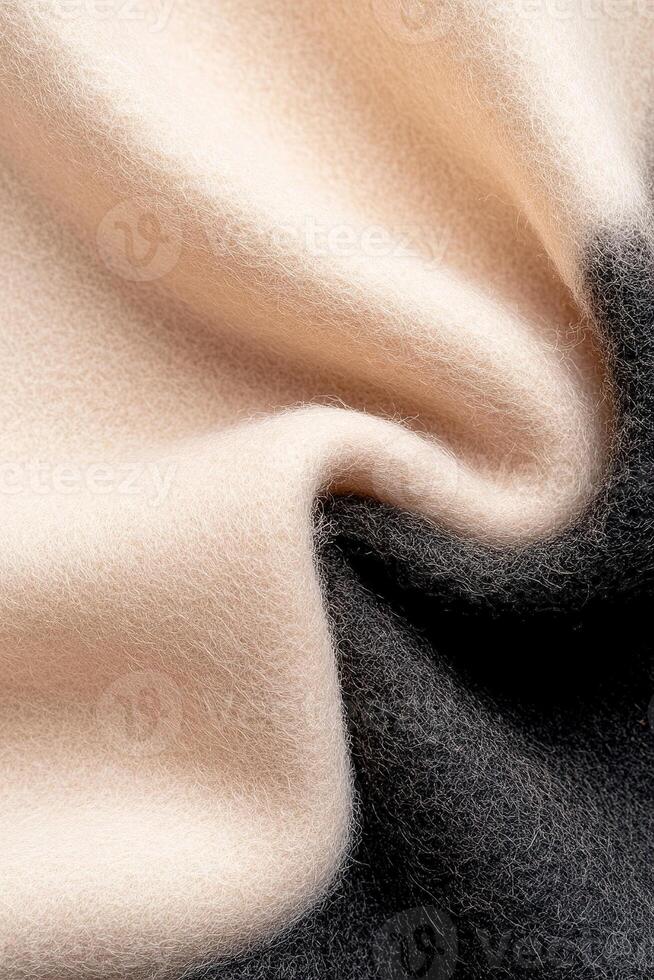 A soft-focus wool surface transitions from a light beige to rich black, creating a striking gradient. This contemporary textile embodies a sophisticated fashion style photo