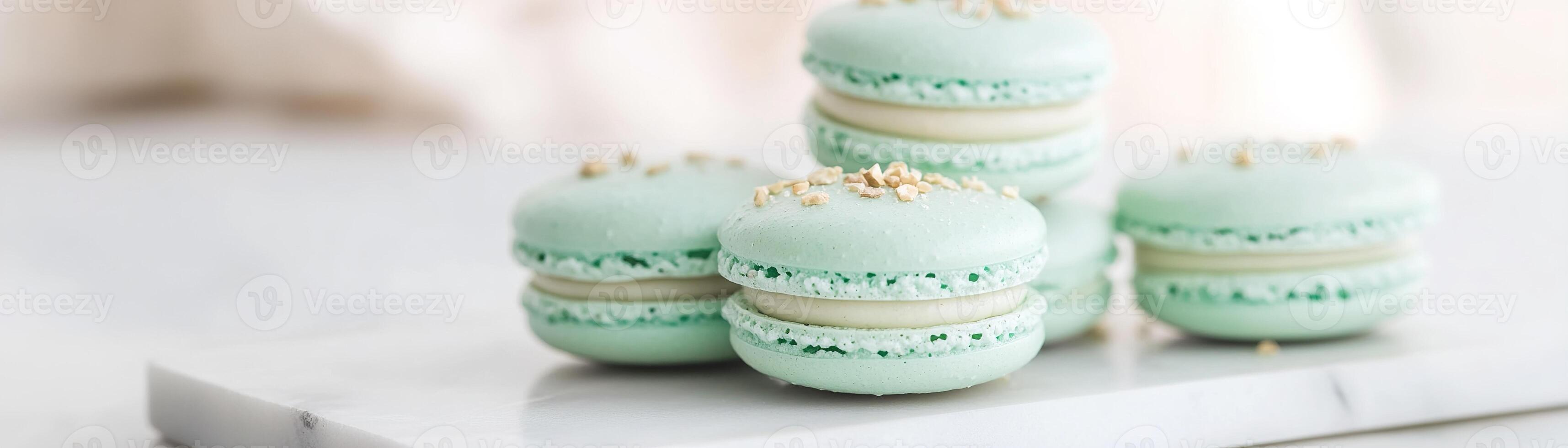 Softly stacked on a white marble tray, these pastel-green pistachio macarons feature a gentle dusting of crushed nuts and enjoy the embrace of natural light, creating an inviting dessert display photo