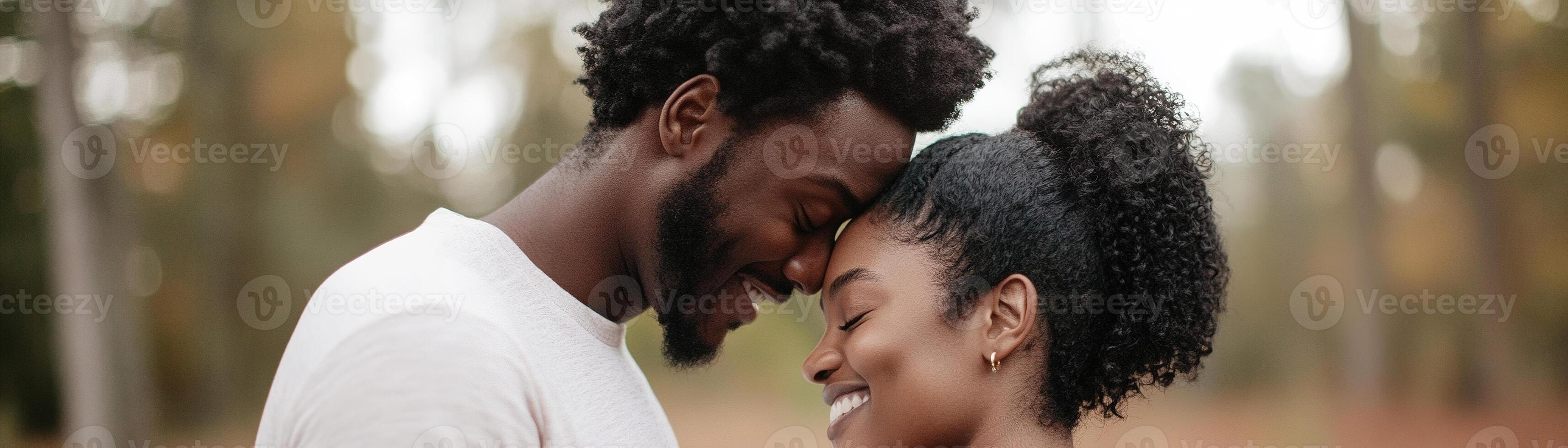Father-to-be gently rests his head on the mother's belly, sharing laughter as the baby kicks, creating a warm and intimate moment in a softly blurred home background photo
