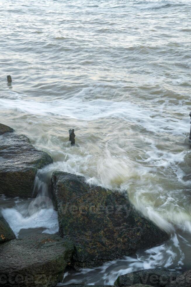 there is a storm at sea. sea waves are beating against the rocks. the photo was taken with a long exposure