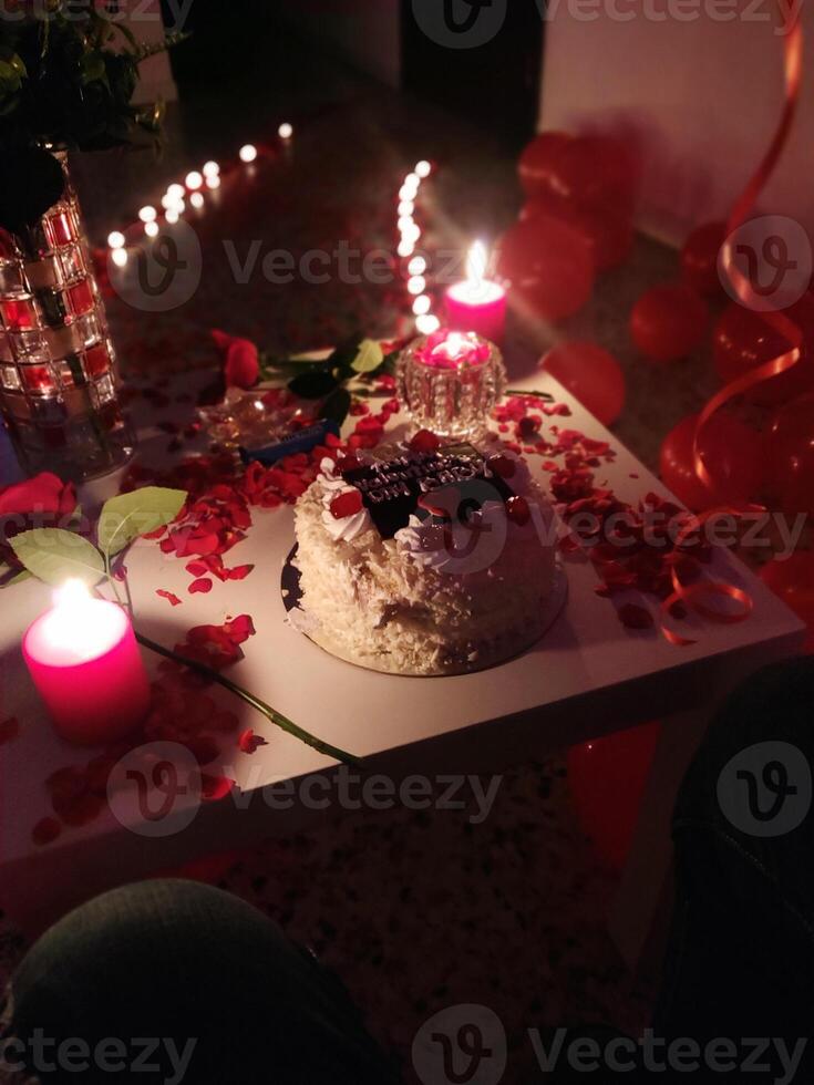 A cake on a table with candles and red balloons photo