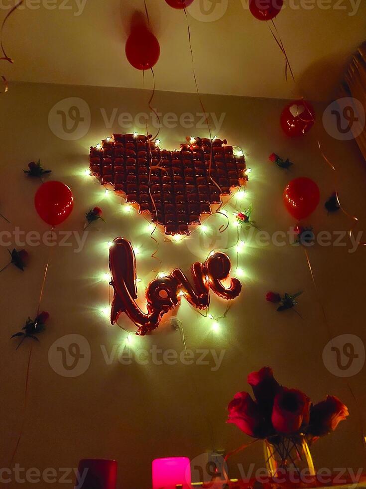 A heart shaped lighted sign with balloons and a heart photo