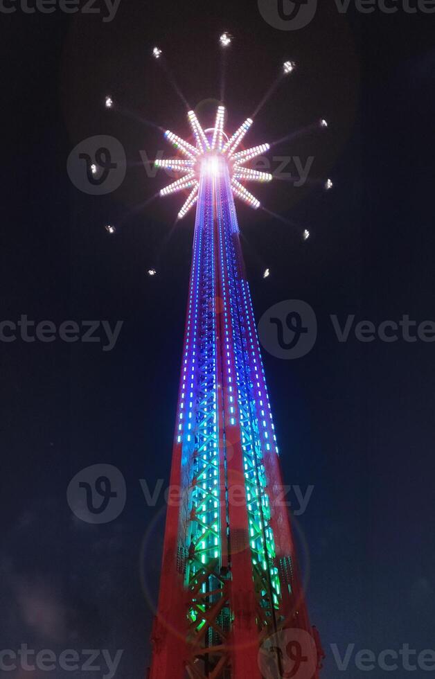 A colorful tower with lights on it at night photo