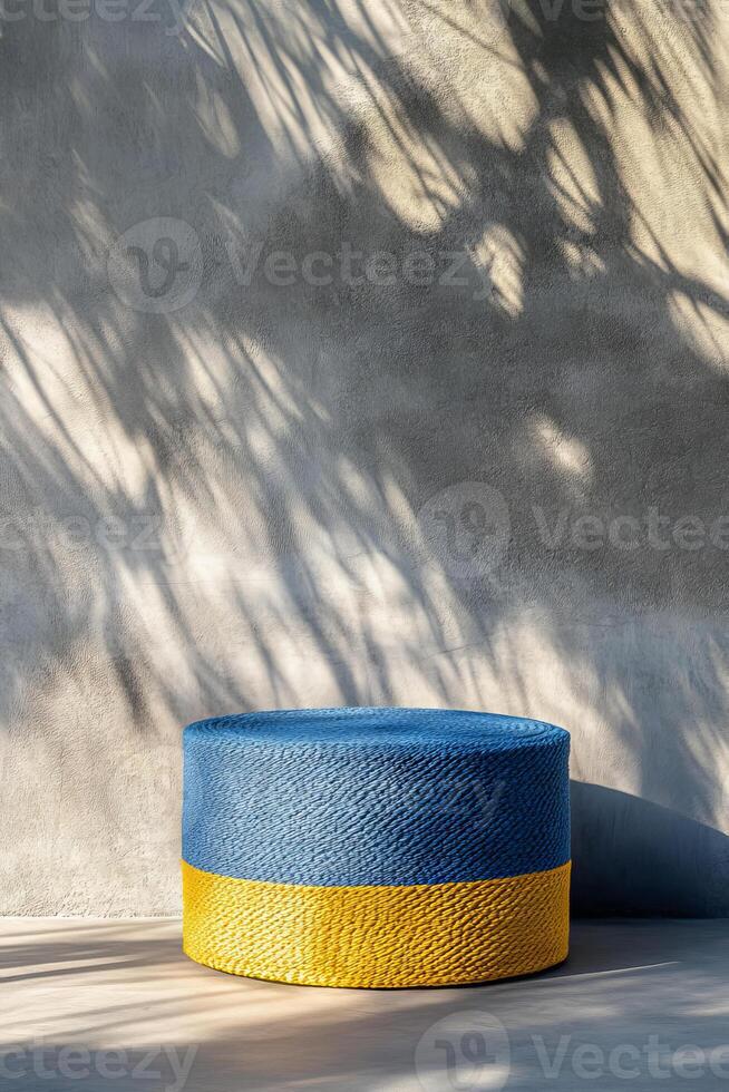 vibrant blue and yellow woven ottoman sits against textured wall, casting interesting shadows. This stylish piece adds pop of color to any modern space photo