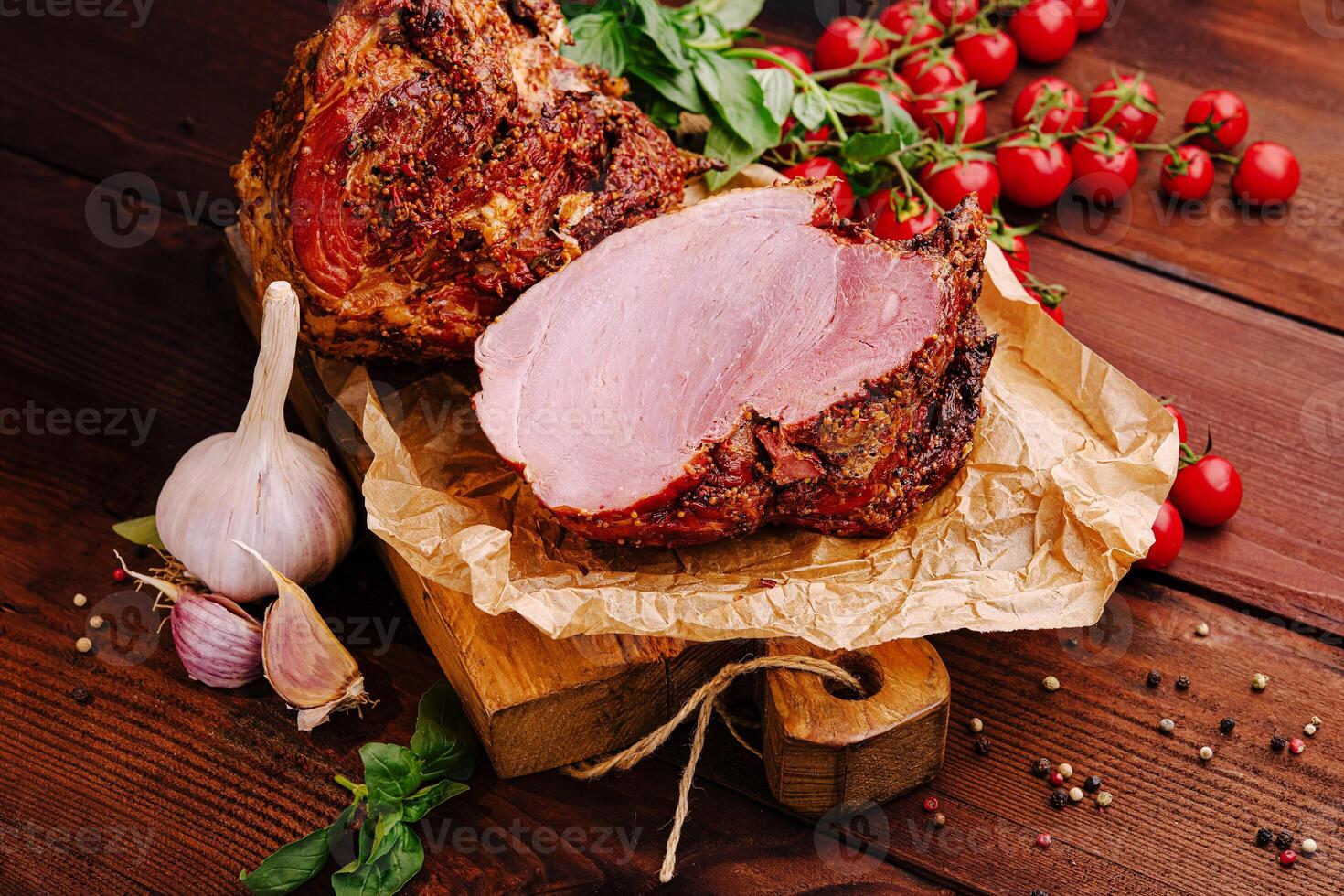 Sliced roast meat served on a wooden board with fresh herbs and tomatoes against a rustic wooden backdrop photo