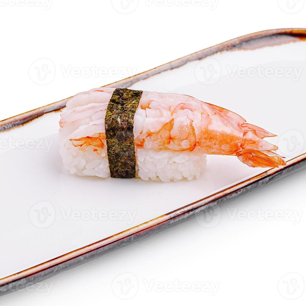 Sushi made with shrimp and rice on a rectangular white plate in a minimalistic setting photo