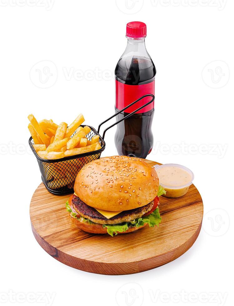 Delicious burger meal served with golden fries, refreshing soda, and savory sauce on a wooden platter photo