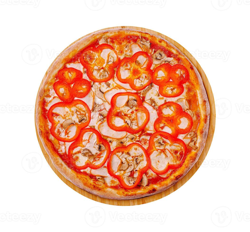Delicious pizza topped with red bell peppers and chicken on a wooden board ready to be served photo