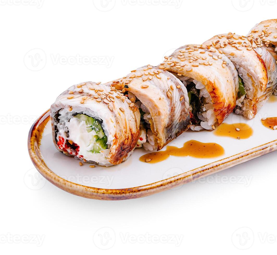 Delicious sushi rolls presented on a white plate drizzled with sauce and sprinkled with sesame seeds photo