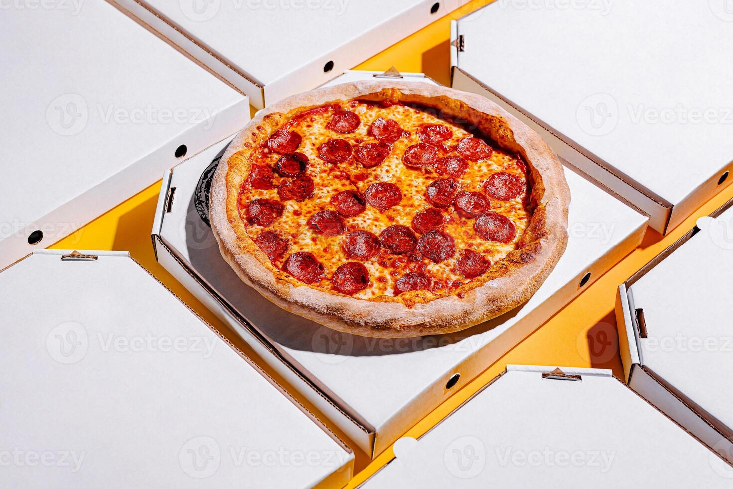 Delicious pepperoni pizza served in delivery boxes on a colorful background during the day photo