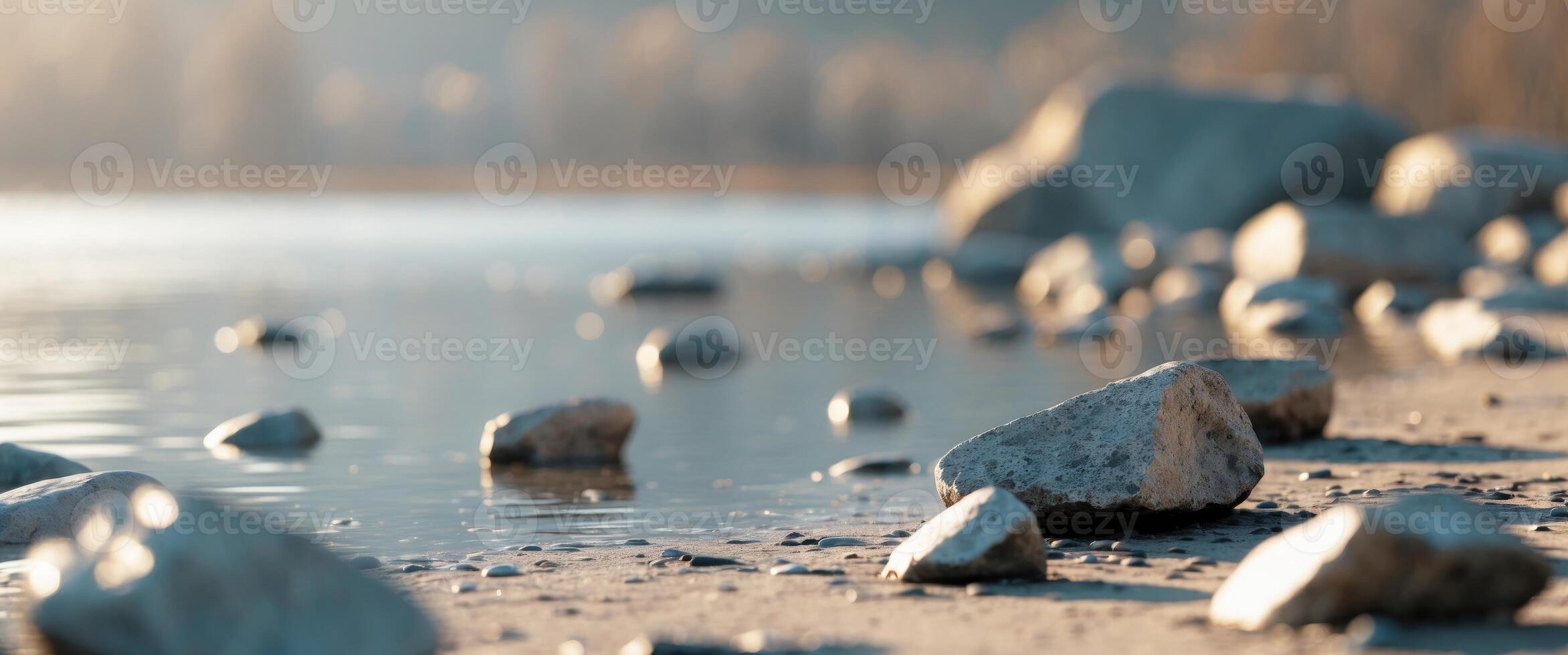Scattered Rocks on Ground by Water in Soft Daylight. photo