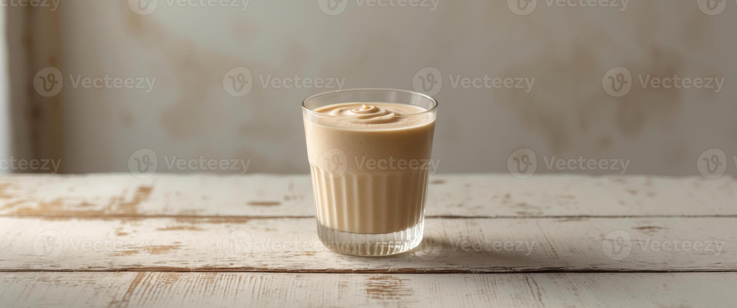 Creamy Beige Smoothie in Glass on Wooden Table. photo