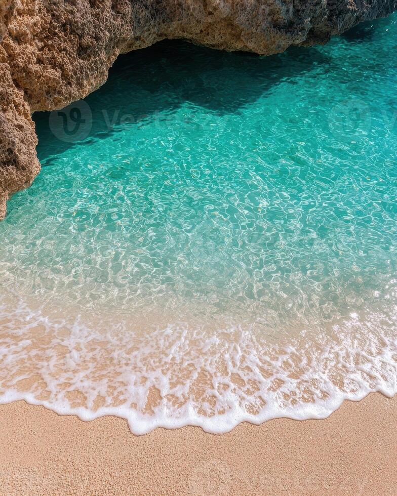 Crystal clear turquoise water lapping onto a sandy beach photo