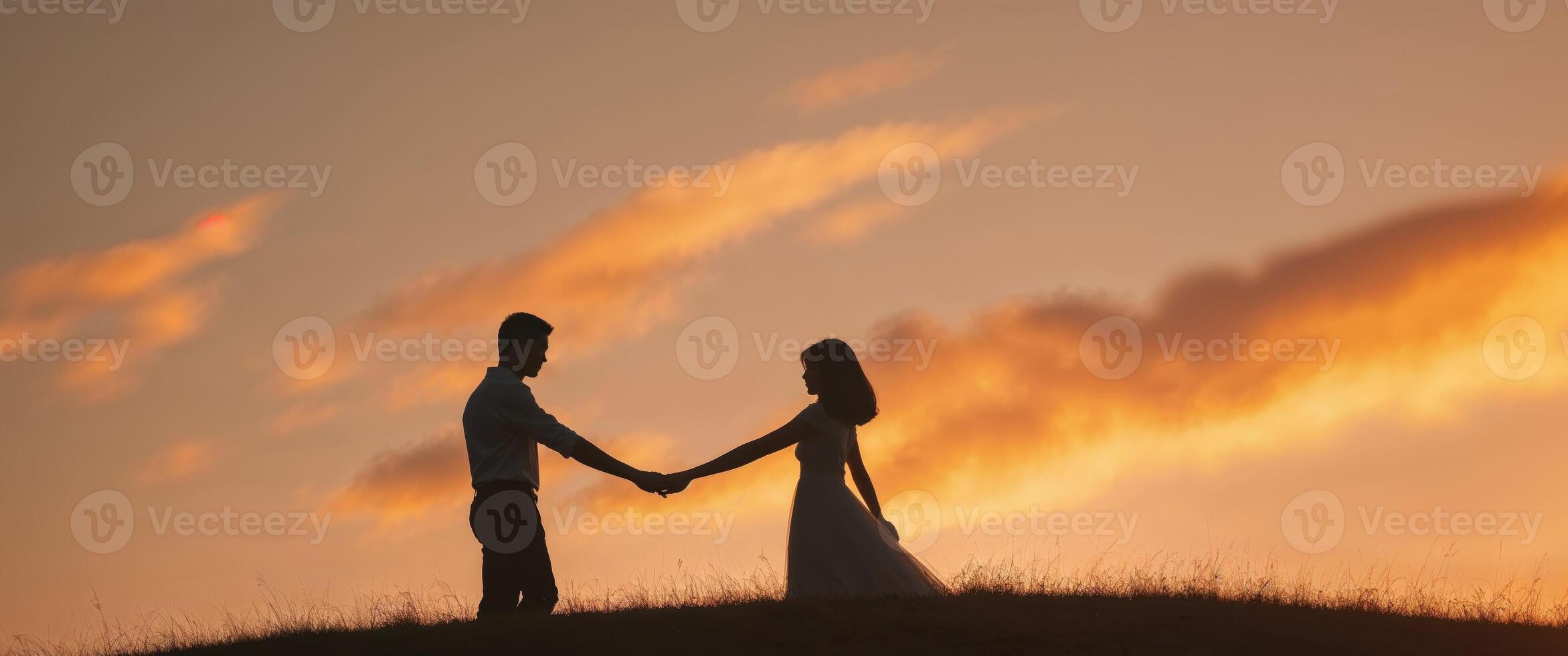 Silhouette of a couple holding hands at sunset photo