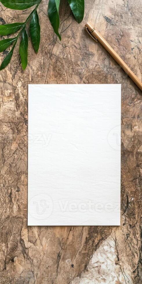 Blank white paper with pen and plant on marble background photo