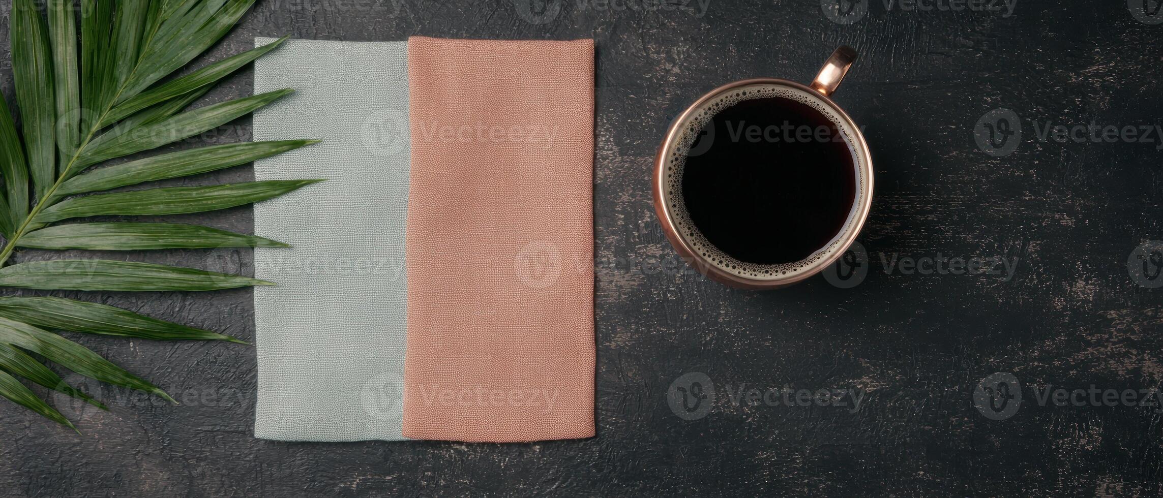Overhead view of coffee, palm leaf and towels on dark background photo
