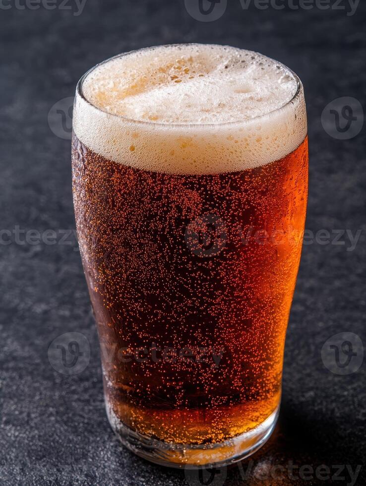 Refreshing pint of amber ale with foam photo